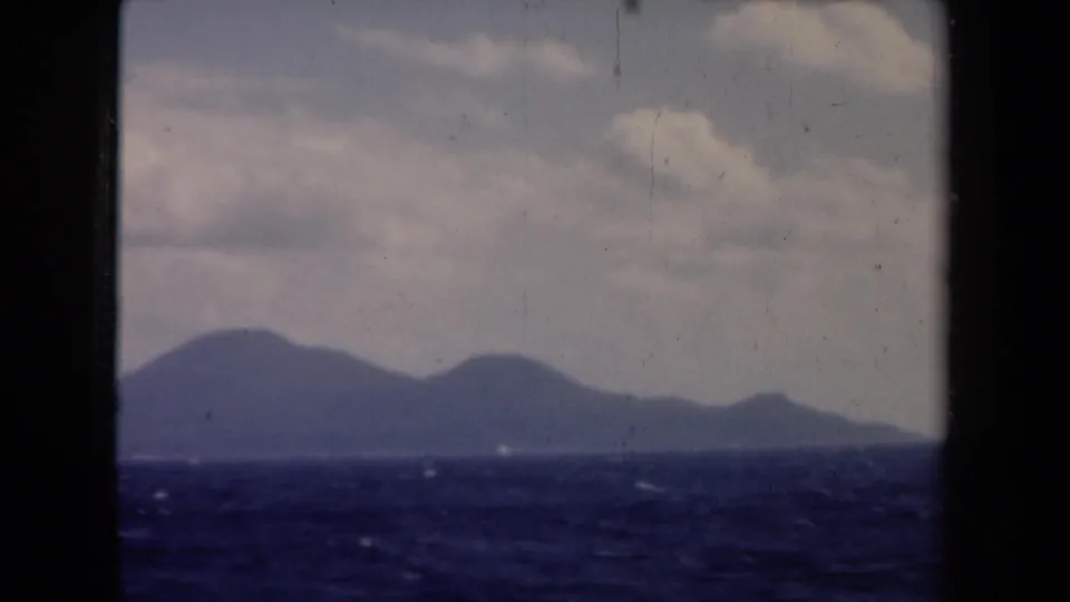1946 Netherlands 8mm frame with dark sea in the foreground and a low mountain or island profile in the distance.