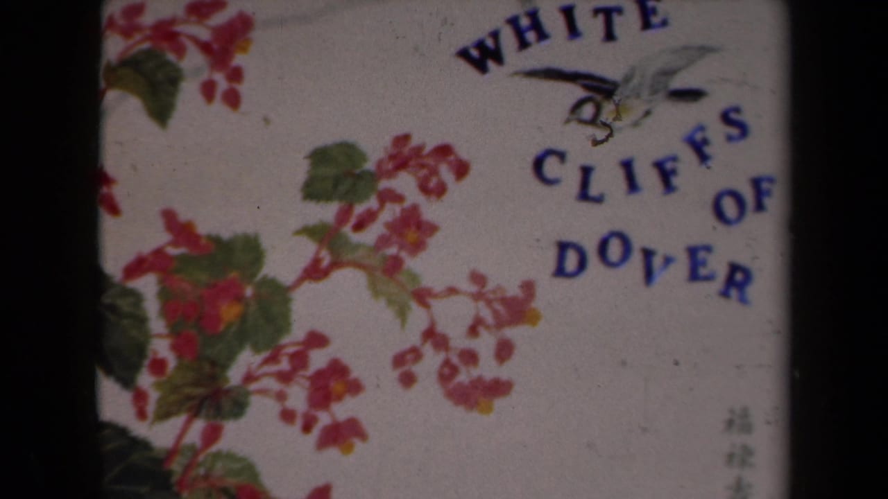 1946 8mm home-movie title card for White Cliffs of Dover, decorated with flowers and curved blue lettering.