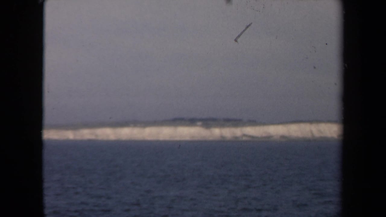 White coastal ice formation seen across water with black film borders.