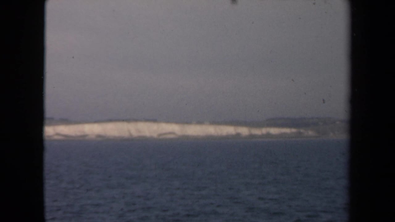 Open water and distant pale shoreline framed by a dark central window edge.