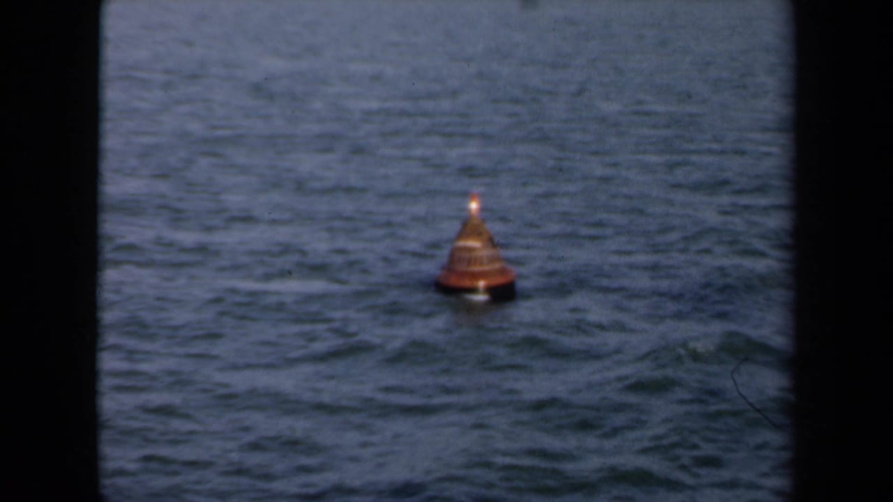 An orange buoy floats in blue-gray water off the Netherlands coast in this 1946 8mm home-movie frame.