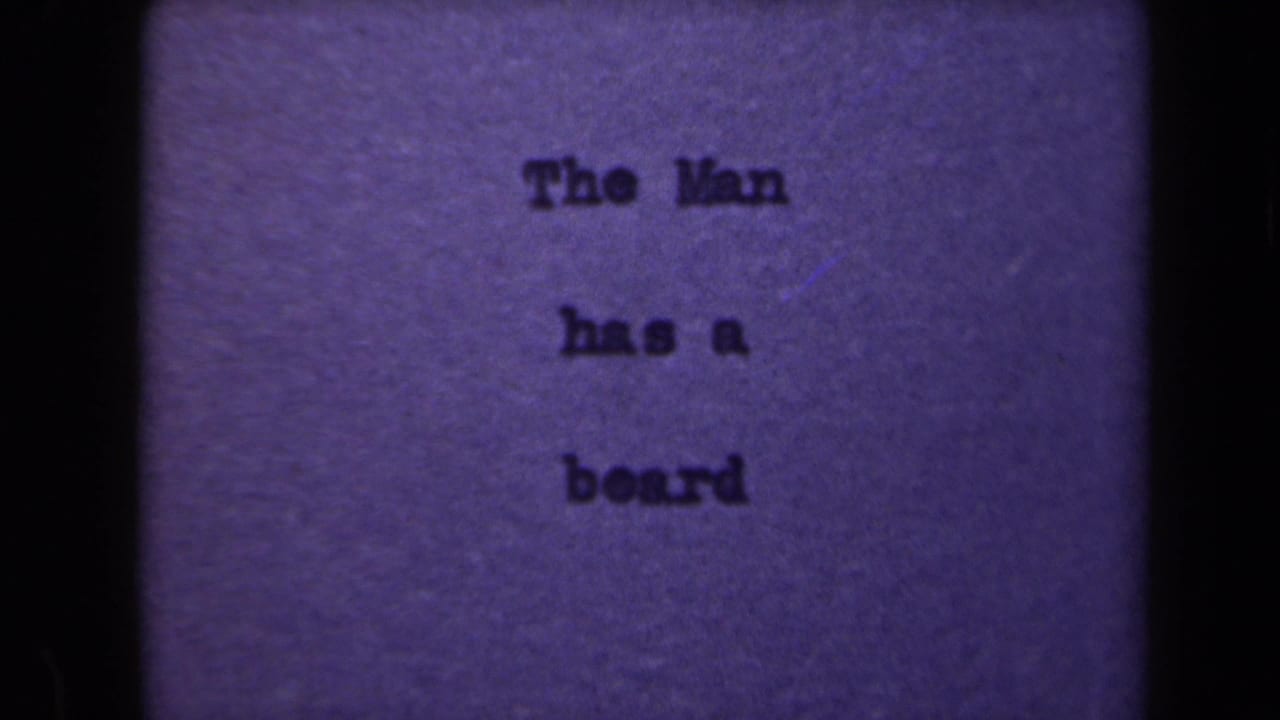 Typed title card with the words The Man has a beard, framed by dark film edges.