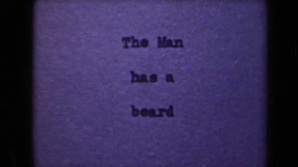 Metadata-supported 1946 Netherlands 8mm frame with a typed note, The Man has a beard, centered on a purple-toned card.