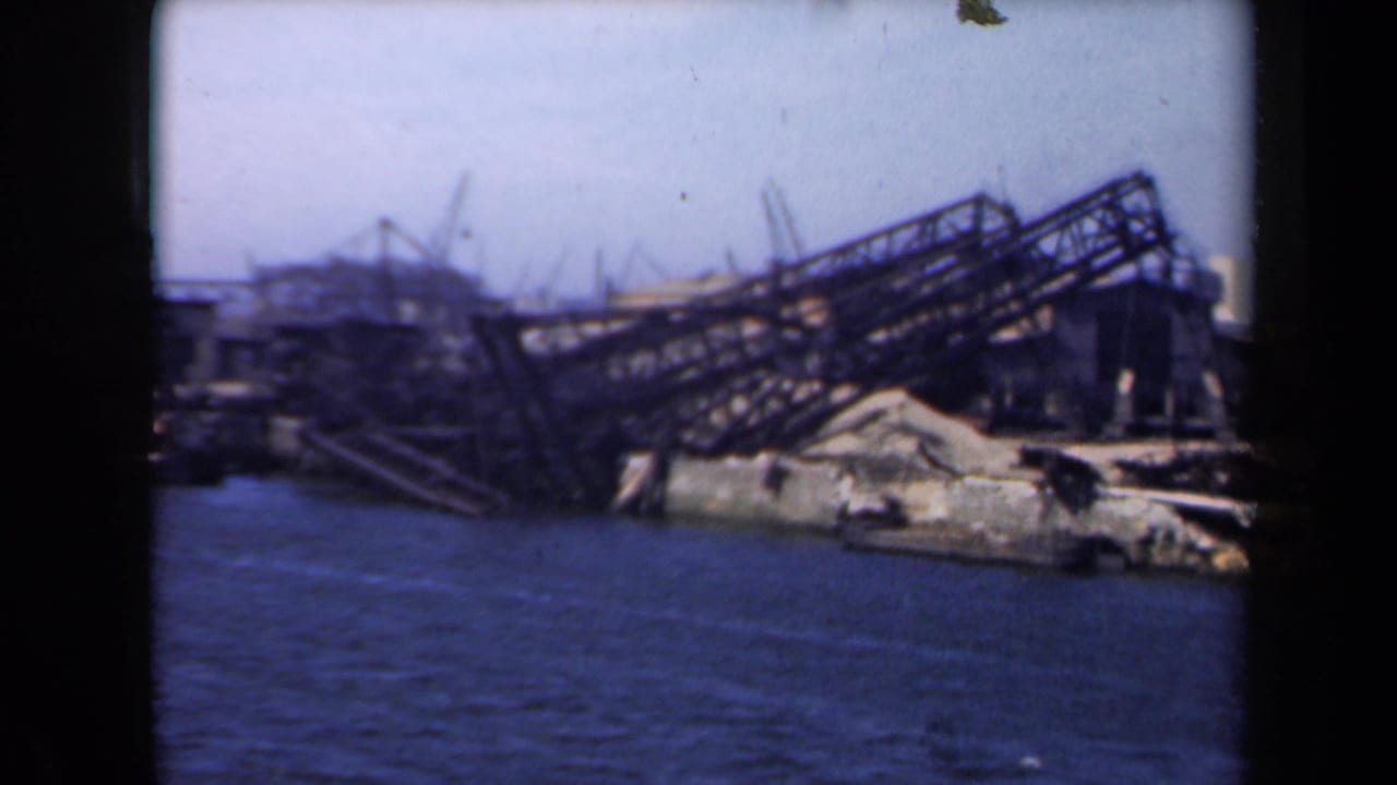1946 Netherlands 8mm view of collapsed metal framework and rubble along a damaged port waterfront.
