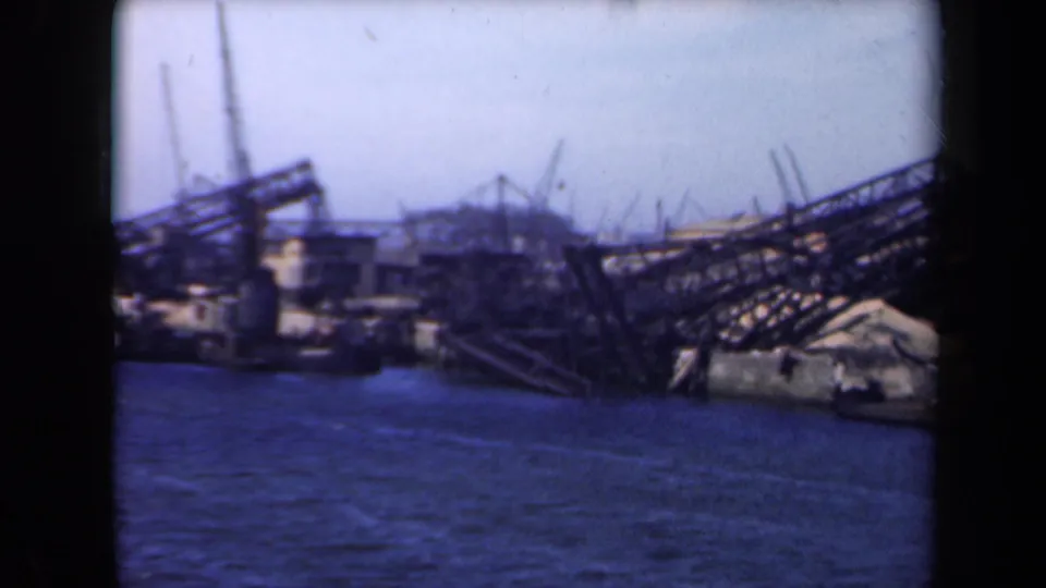 1946 Netherlands port scene with debris, collapsed metal structures, and cranes or masts beyond the waterfront.