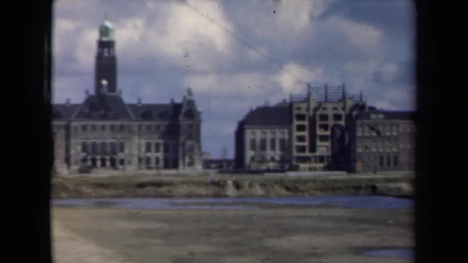 Final 1946 Netherlands frame shows the towered riverside building with additional adjoining structures to the right and muted 8mm color texture.