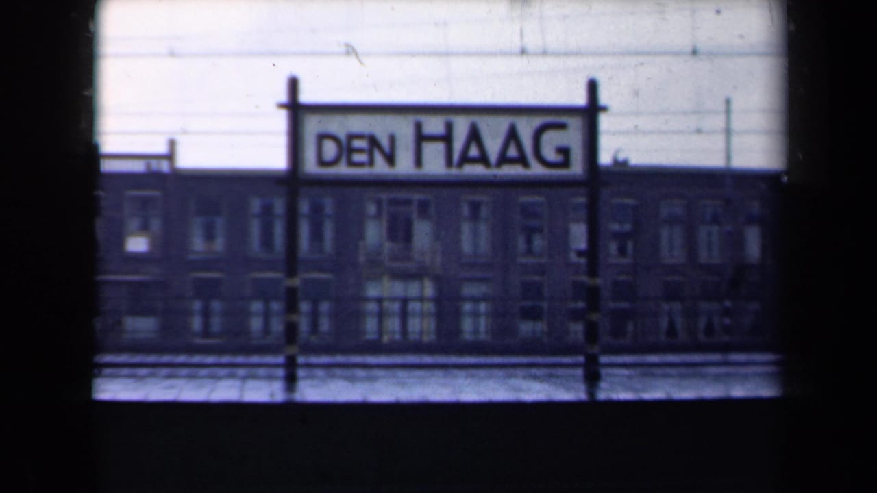 Den Haag station sign centered above a dark brick building facade.