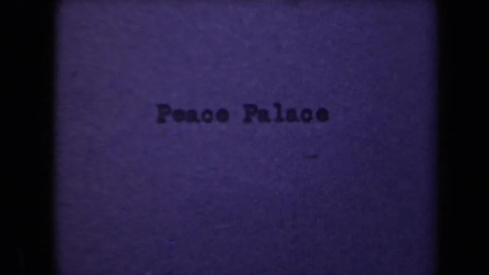 1946 8mm title card reading Peace Palace, seen through a soft blue-purple film frame with dark vertical edges.