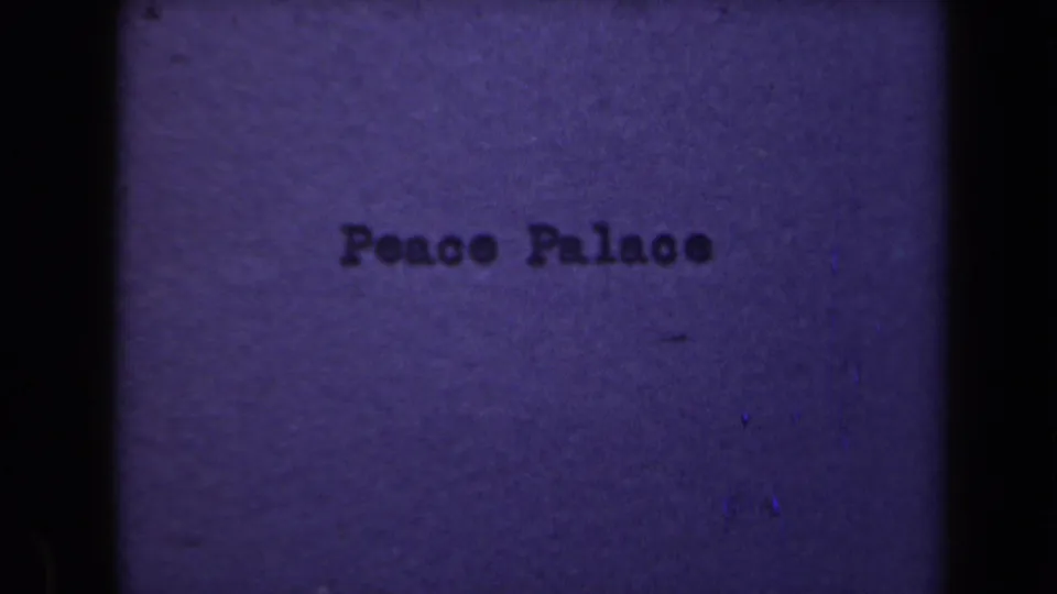 Typed Peace Palace title remains visible in a grainy 8mm frame before the cut to the building exterior.