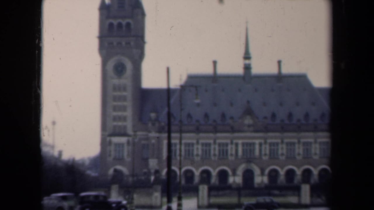 Tall historic building with a clock tower seen through dark frame edges.