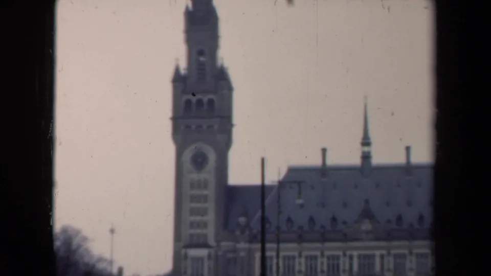 1946 Netherlands 8mm frame with the clock tower shifted left, the roof and arched facade visible through a dark edge.