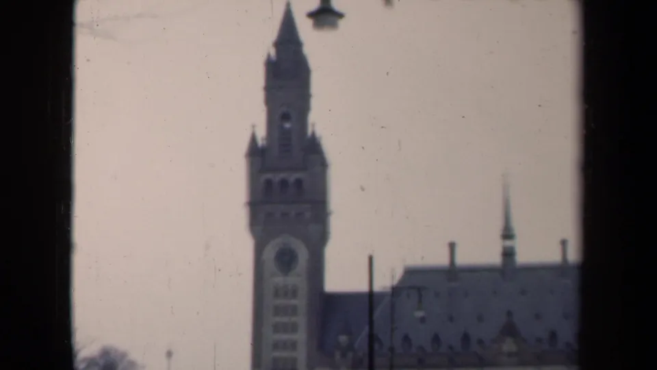1946 Netherlands frame showing the tower and part of the adjoining roof, with lamp posts and dark foreground framing.