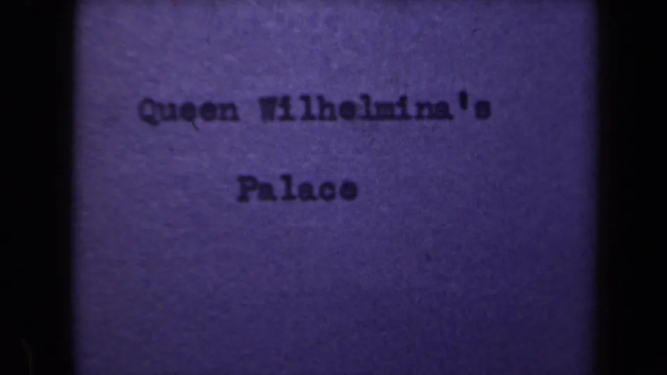 Final 8mm frame holds on the Queen Wilhelmina's Palace title card, with grain and uneven exposure visible.