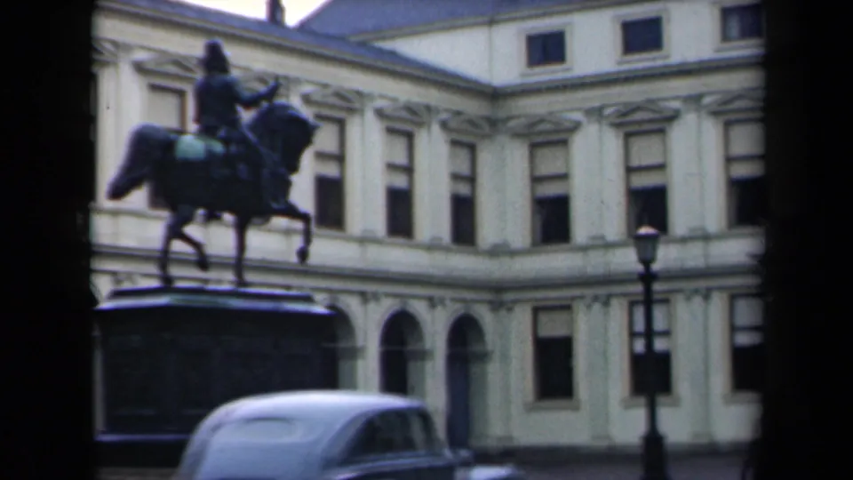 1946 Netherlands frame showing an equestrian statue before a pale classical building, with a light-colored period car partly visible below.