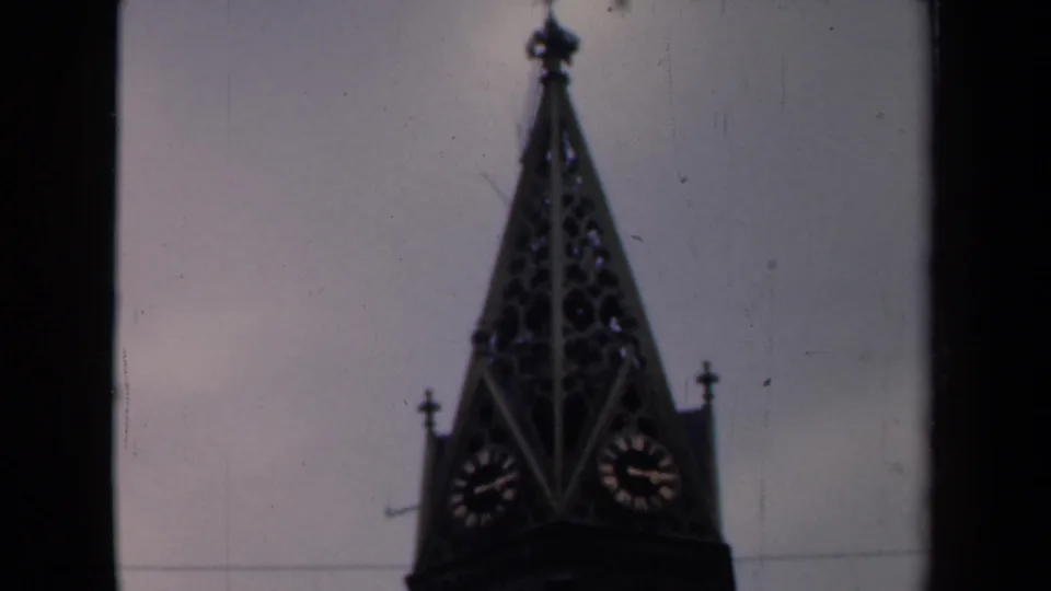 1946 Netherlands frame with an ornate church spire, visible clock faces, and dark vertical film edge.