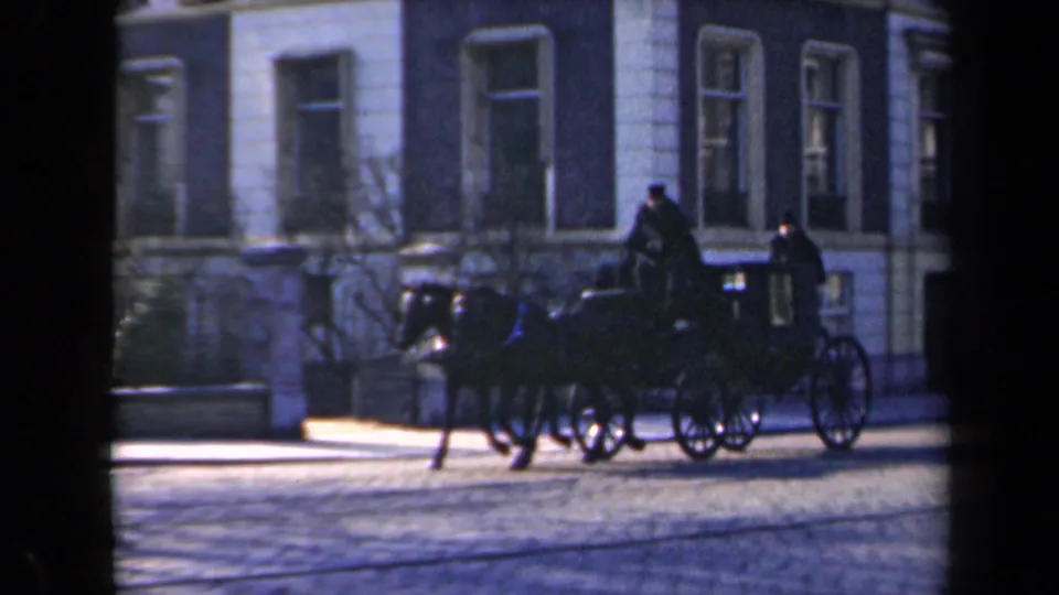 1946 Netherlands street view with a horse-drawn carriage, distant people, cobblestones, and a formal building facade.