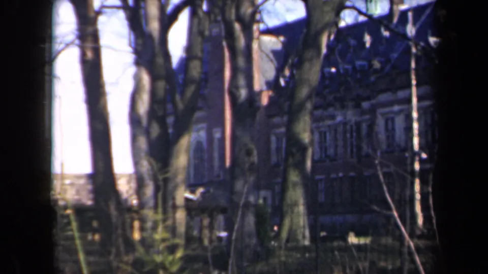 A Dutch mansion exterior appears behind winter trees in this soft 8mm frame from the 1946 home-movie clip.