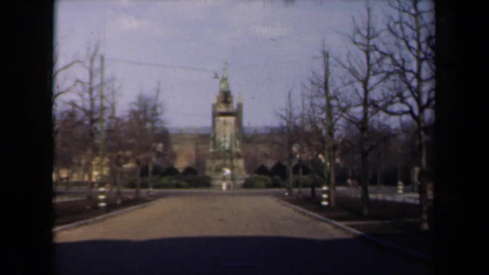 1946 Netherlands home-movie view down a broad path toward a distant tower or monument, framed by bare trees and soft 8mm color.