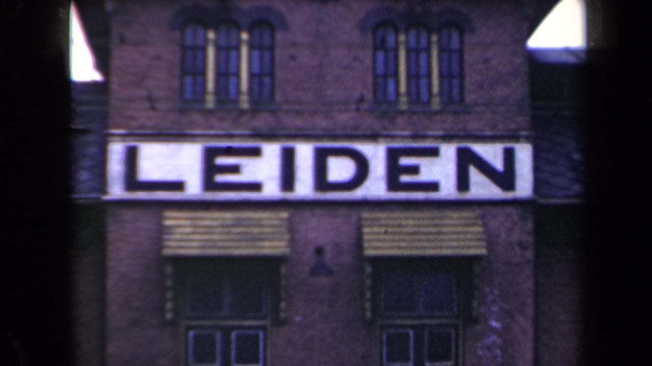Large LEIDEN sign across a brick building with upper windows and striped awnings.