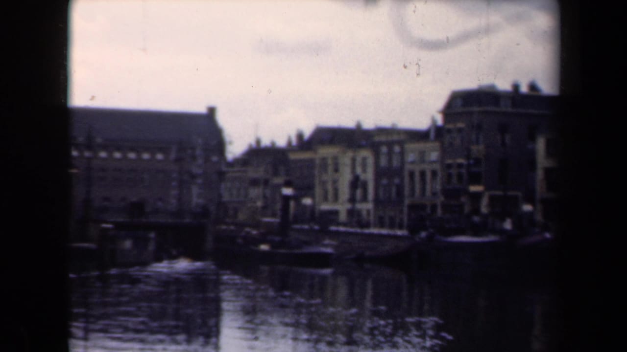 Canal and waterfront buildings seen through a soft, grainy 8mm frame.