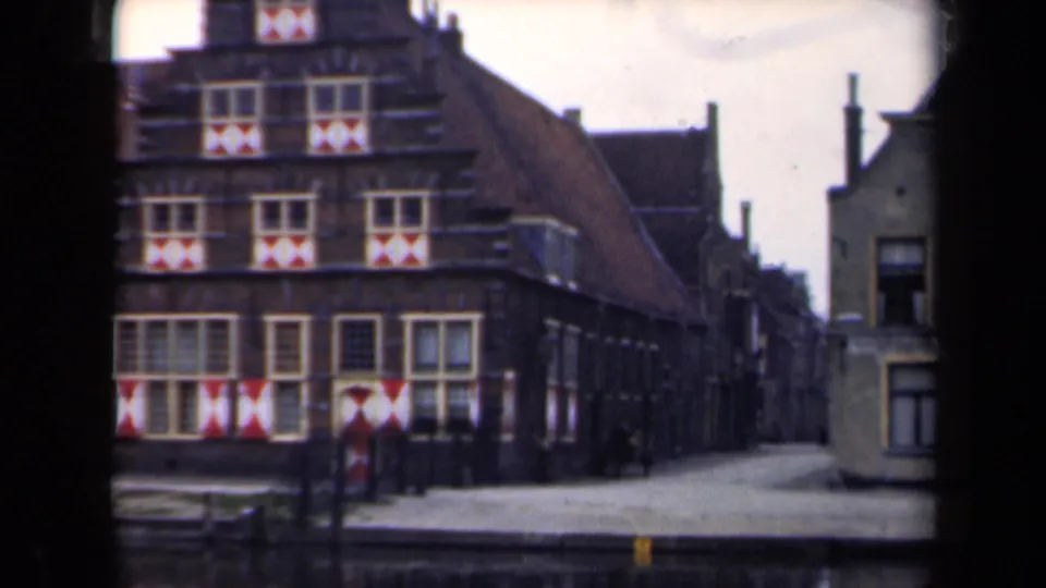 1946 Netherlands street frame with the gabled facade partly cropped and the adjacent narrow street receding into the distance.