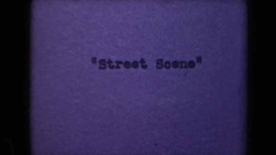 Title card from the 8mm reel with typed text reading Street Scene on a purple-toned background.