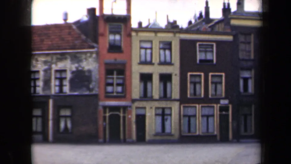 1946 Netherlands 8mm frame with street-facing Dutch facades, tiled roof sections, chimneys and multi-paned windows.