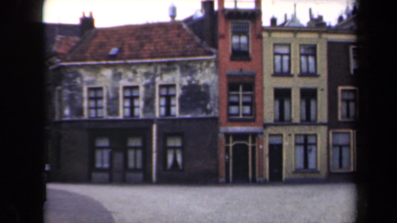 Connected town buildings with varied facades and a quiet street in front.