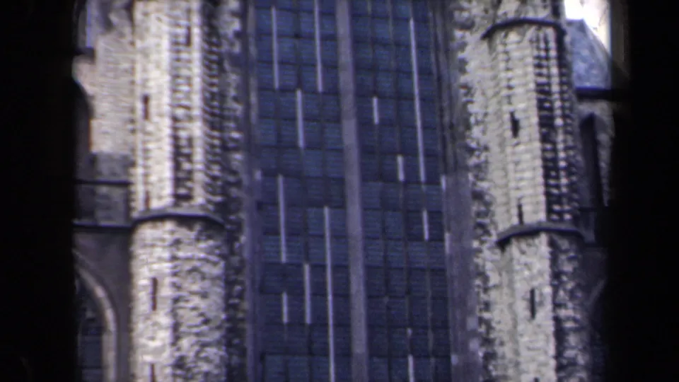 1946 Netherlands 8mm frame with pale stone Gothic-style verticals beside tall dark window panels, seen through a contact-sheet scan.