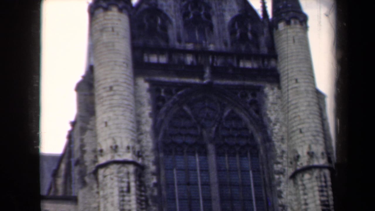 Gothic church facade with paired round towers and dark pointed window openings.