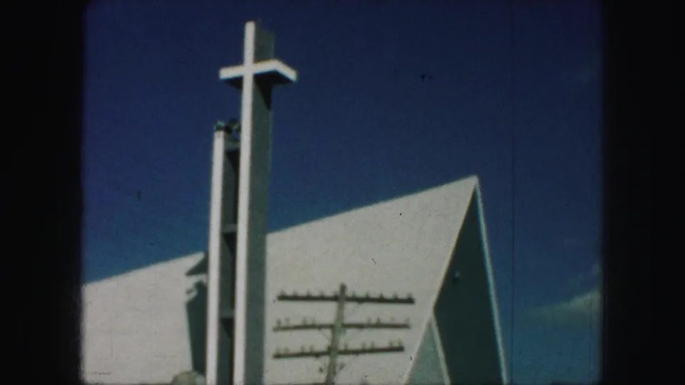 1959 Kansas City 8mm view with the cross at the top of the steeple more prominent above the white angular church exterior.