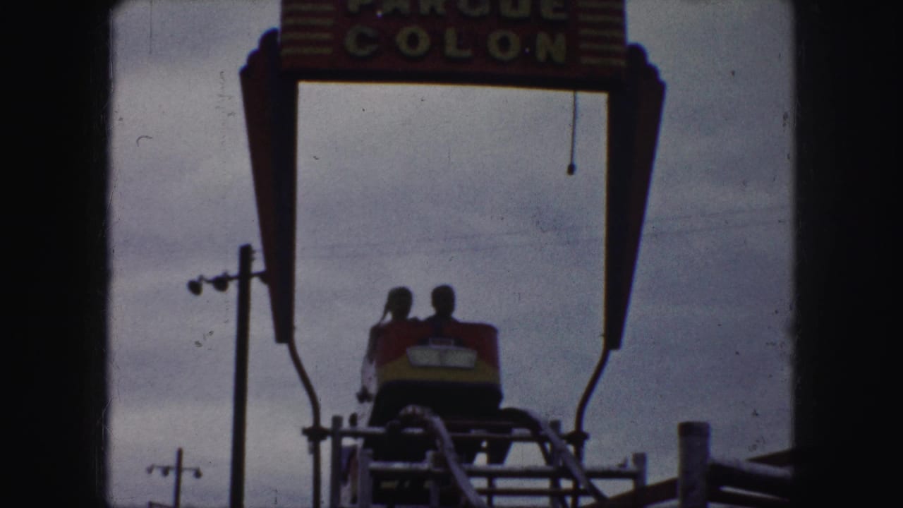 Riders in a red and yellow coaster car appear beneath the Parque Colon sign in Kansas City home-movie footage.