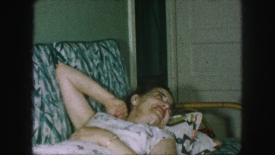In the final frame, the woman reclines in the patterned chair and laughs near the white paneled door of the private interior.