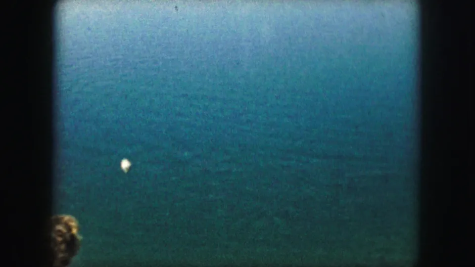 1959 8mm home-movie frame with the person mostly cropped out and the water surface dominating the view.