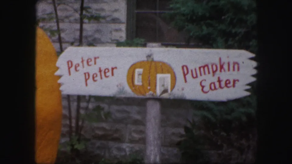 1959 Kansas City home-movie frame of the Peter Peter Pumpkin Eater sign, with red lettering and a painted pumpkin doorway motif.