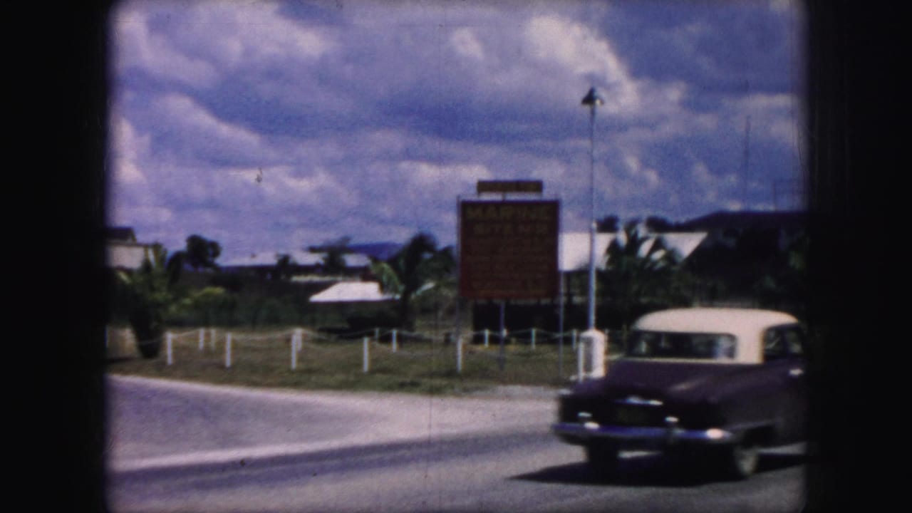 Classic two-tone sedan passing a roadside Marine Site No. 2 sign.