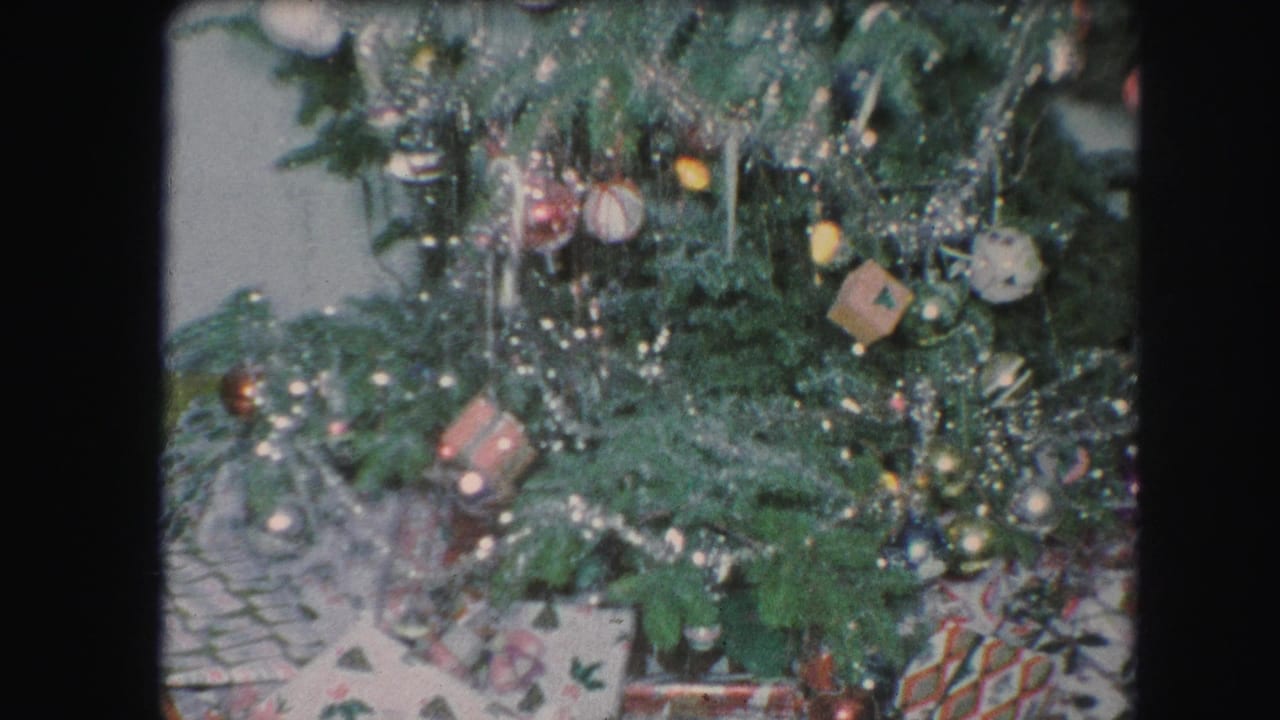 Decorated Christmas tree with tinsel, ornaments, lights, and wrapped presents underneath.