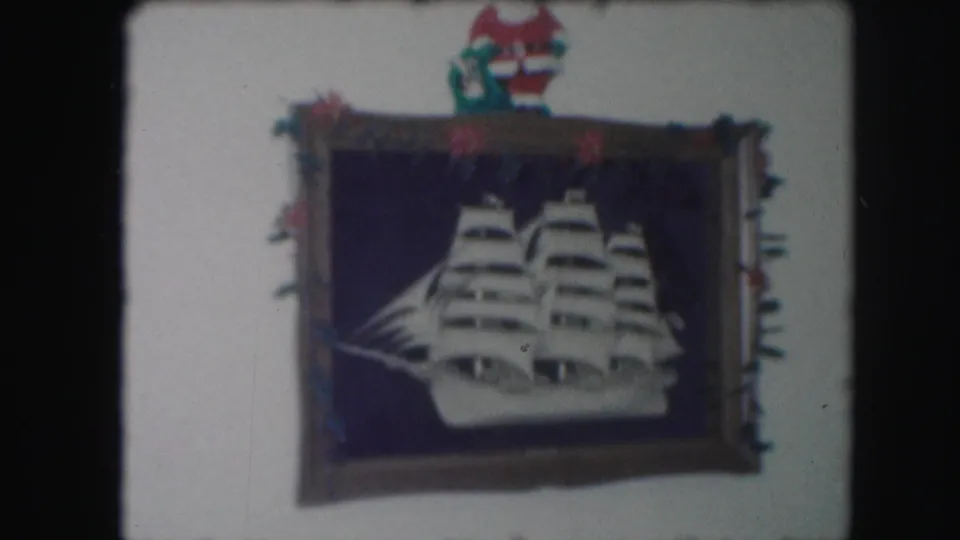 1959 Kansas City frame of a white sailing ship cutout on a dark blue background, with red and green holiday trim and a Santa figure above.