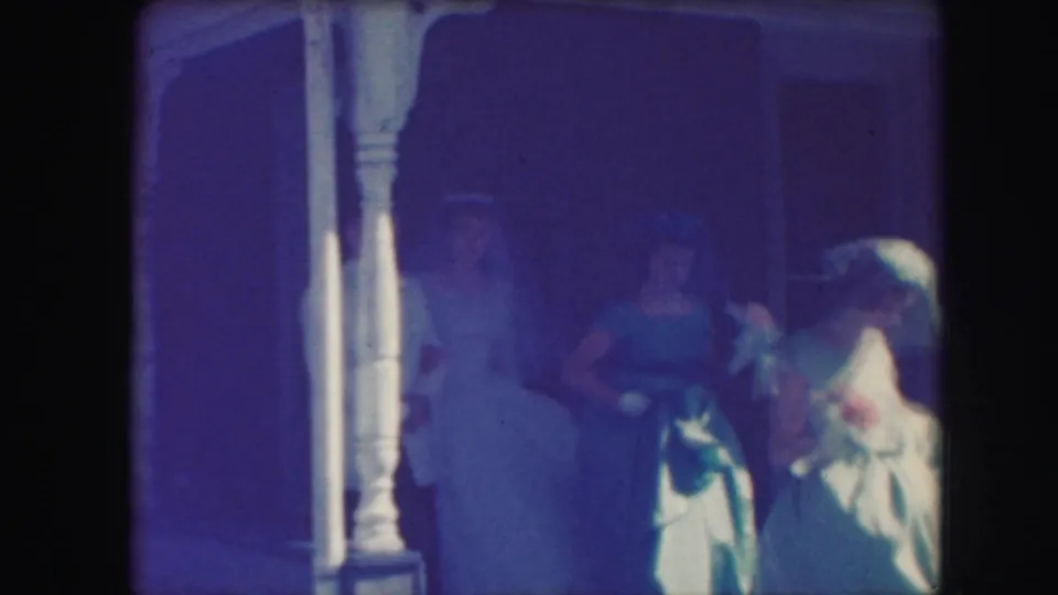 1959 Kansas City wedding party on a porch, with blue dresses, white veil, bouquets, and shaded doorway visible.
