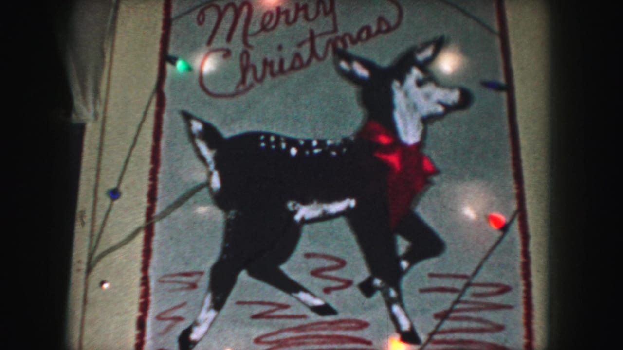 Reindeer decoration with Merry Christmas lettering and small colored lights near the edges.