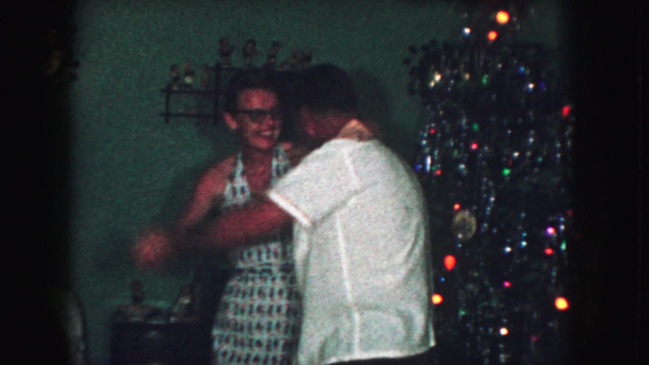 In Kansas City, Missouri 1959 home-movie footage, an adult couple dances near a decorated Christmas tree in a private living room.