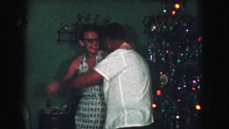 In Kansas City, Missouri 1959 home-movie footage, an adult couple dances near a decorated Christmas tree in a private living room.