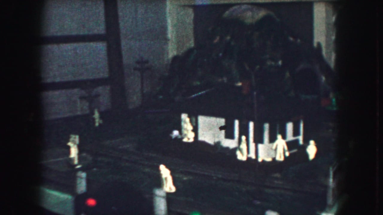 A 1959 Kansas City 8mm frame shows a model village or train layout with tiny figures, dark rails, and bright miniature lighting.