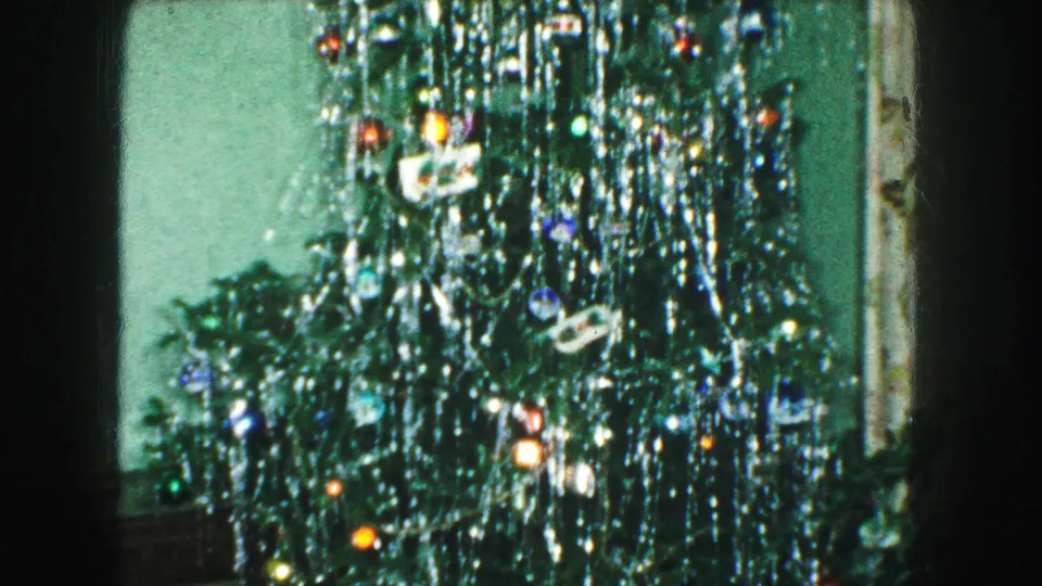 1959 Kansas City interior frame showing the upper Christmas tree branches with silver tinsel, lights, ornaments, and a star topper.
