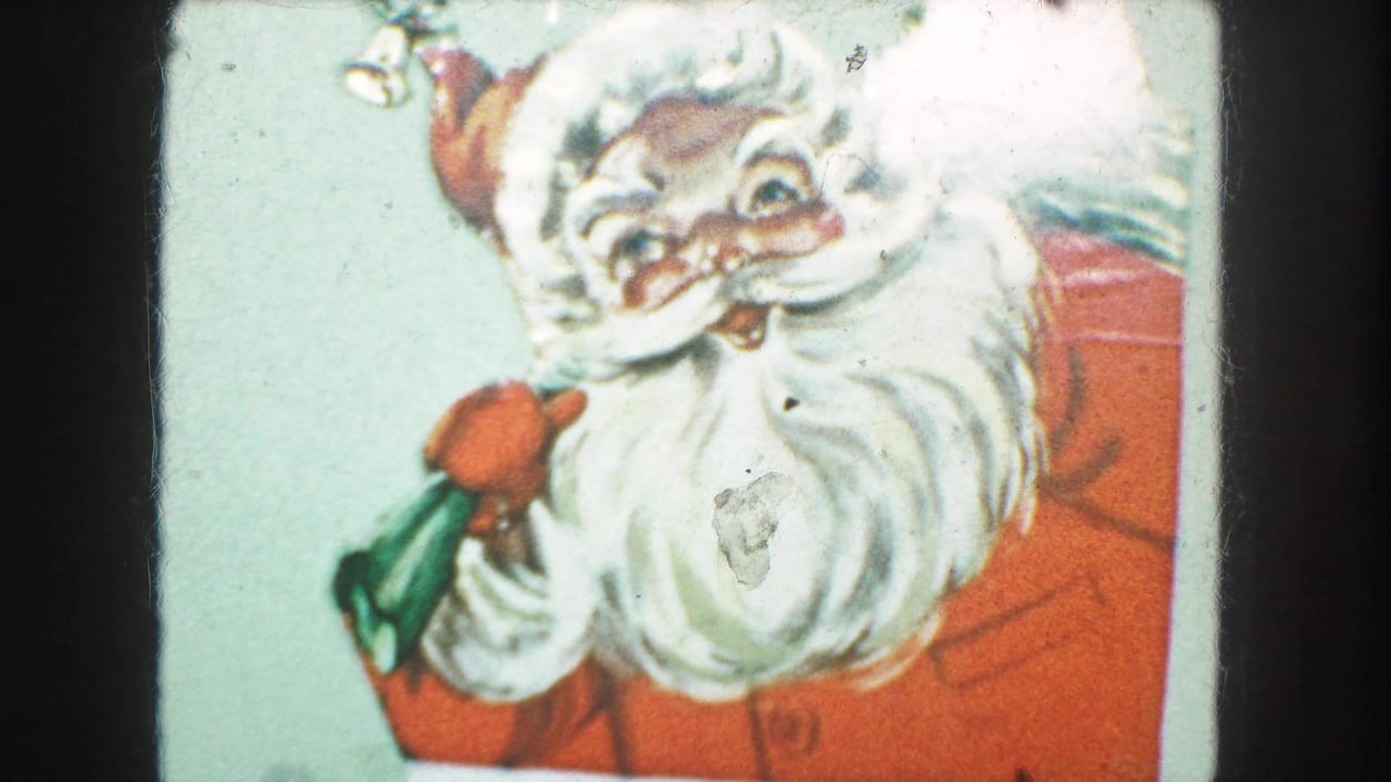 1959 Kansas City home-movie frame showing a cropped Santa illustration on a holiday card with red suit, white beard, and green gift bag.