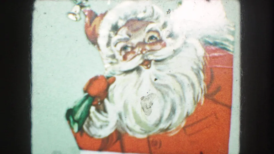 1959 Kansas City home-movie frame showing a cropped Santa illustration on a holiday card with red suit, white beard, and green gift bag.