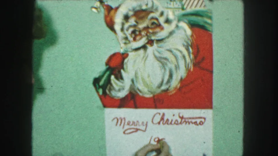 1959 Kansas City 8mm frame showing a Santa card as a hand writes the year beneath Merry Christmas in red cursive.