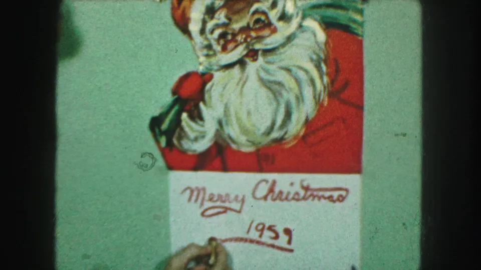 Kansas City 1959 home-movie frame showing a hand finishing and underlining the red date below the Christmas greeting.