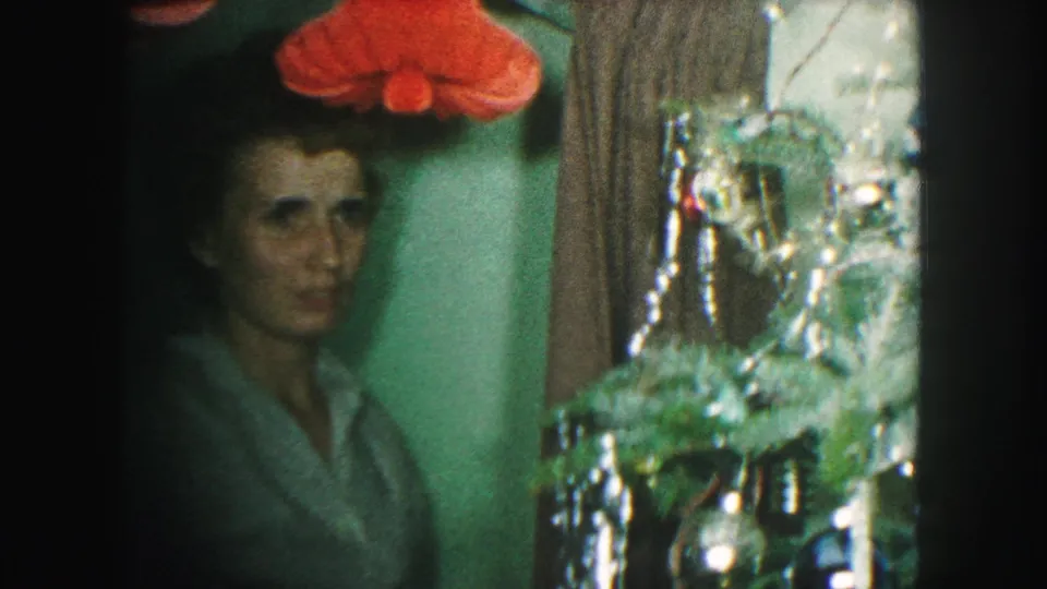 The final frame shows the woman facing the camera near the decorated Christmas tree in a 1959 Kansas City home interior.