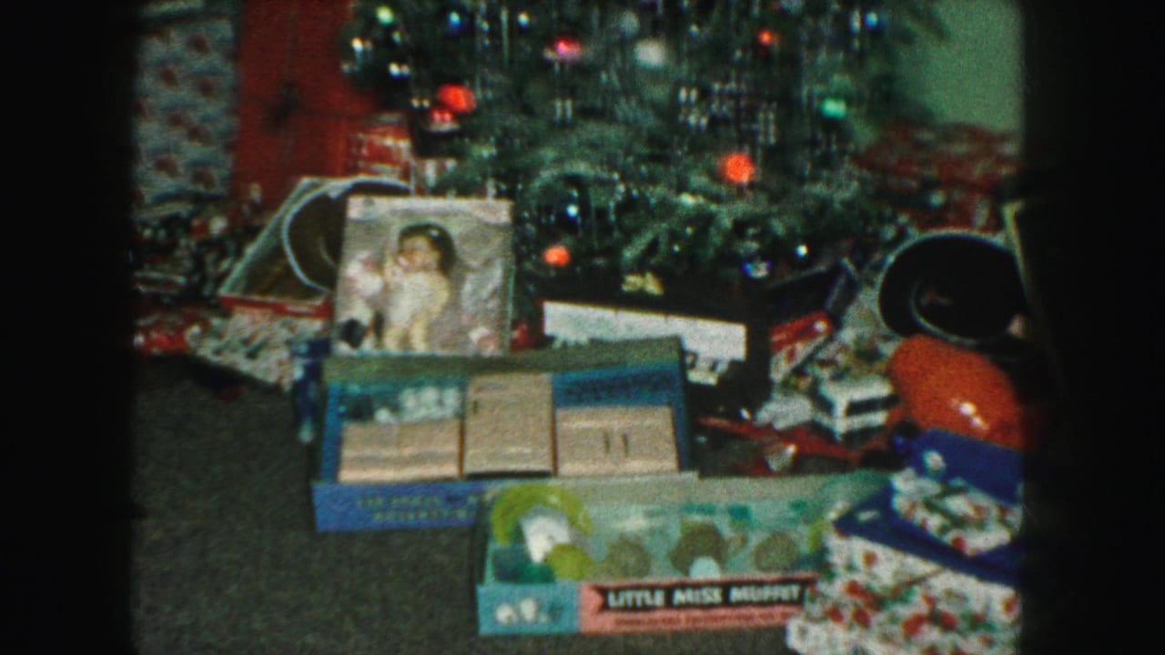 Christmas tree with gifts, toy boxes, doll packaging, and wrapped presents beneath it.
